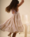 Early Sunday, Laura Dress in Butterfly Print color, made from printed cotton tiny swiss dobby fabric, featuring Crisscross ruffle straps with delicate trim accents and a softly gathered tiered skirt, shown in a Model walking / movement shot