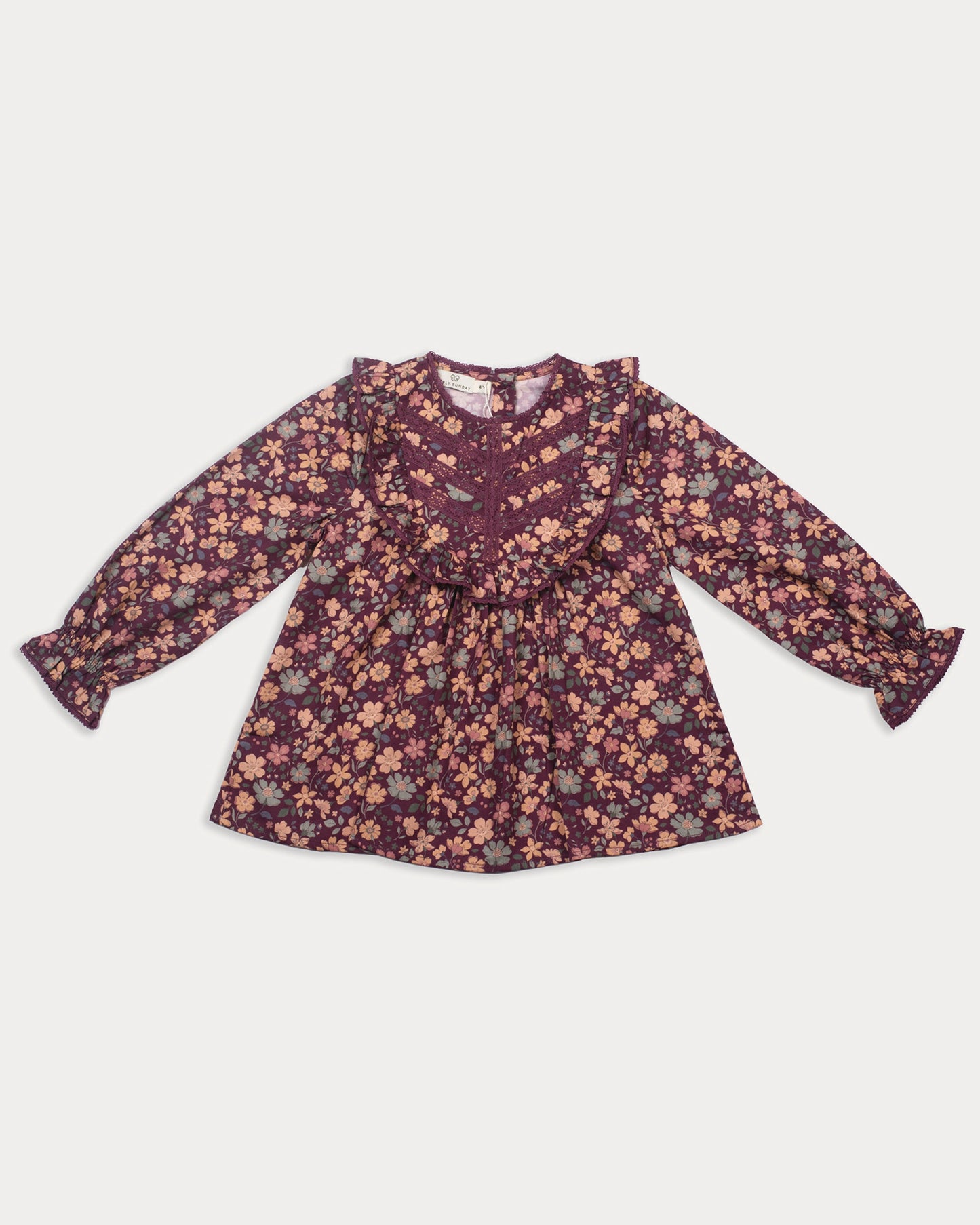 Early Sunday, Lauren Blouse in Plum, made from Printed Cotton Satin fabric, featuring layered lace-trimmed ruffles and delicate pintuck detailing on the yoke, shown in a front flat-lay view