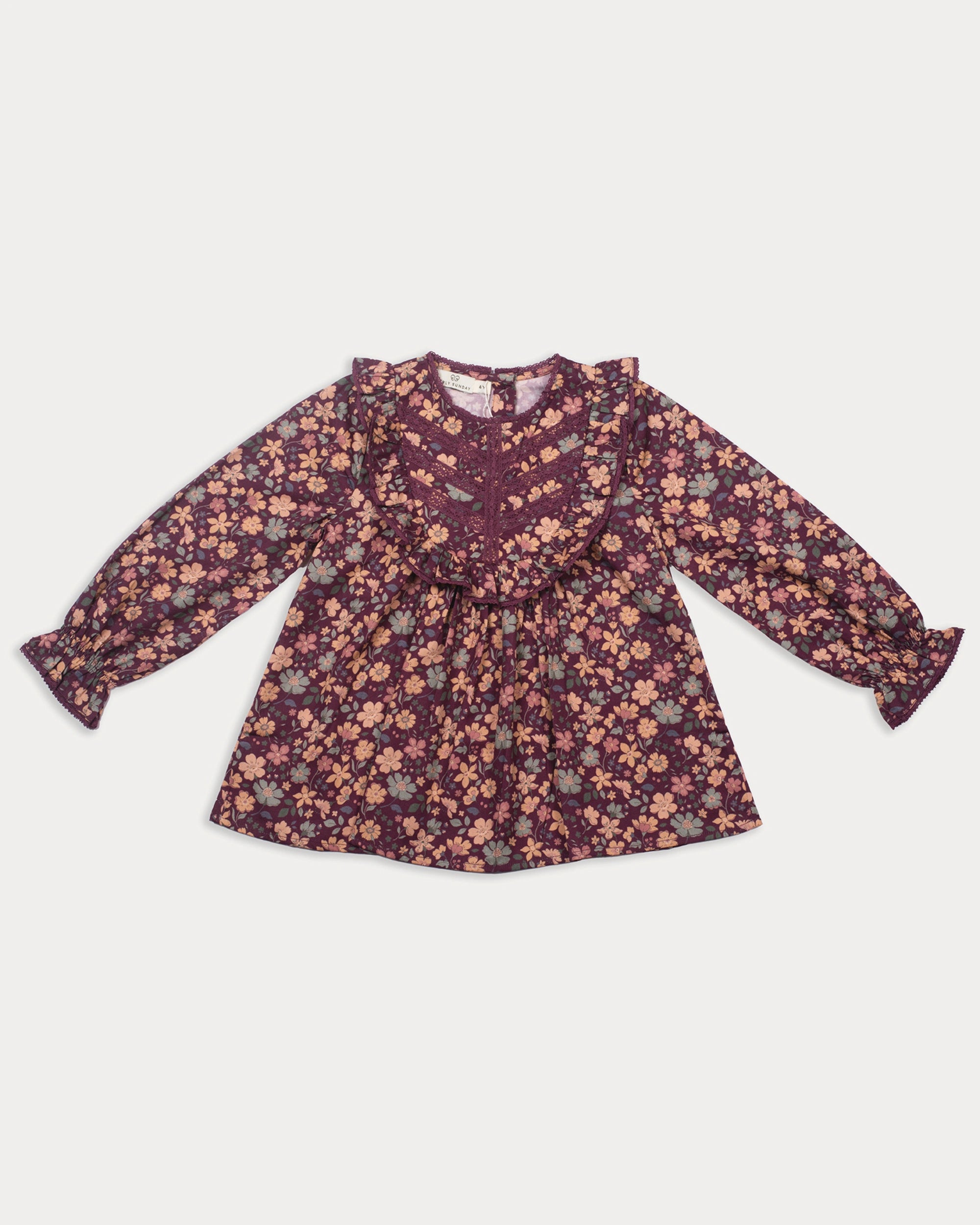 Early Sunday, Lauren Blouse in Plum, made from Printed Cotton Satin fabric, featuring layered lace-trimmed ruffles and delicate pintuck detailing on the yoke, shown in a front flat-lay view