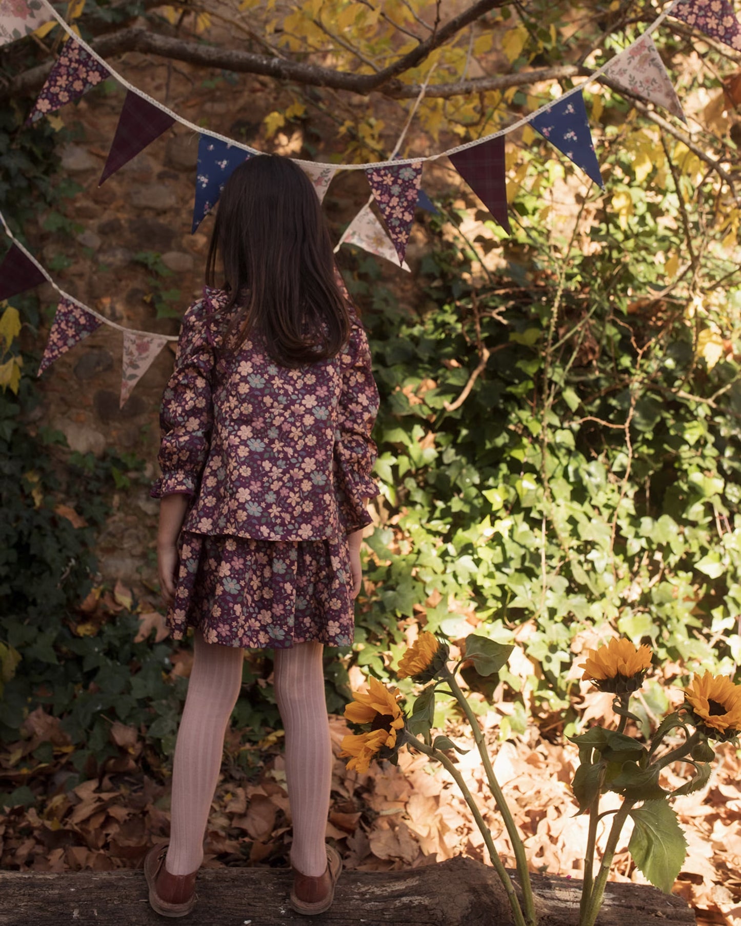 Early Sunday, Lauren Blouse in Plum, made from Printed Cotton Satin fabric, featuring layered lace-trimmed ruffles and delicate pintuck detailing on the yoke, shown in a back view of model wearing it