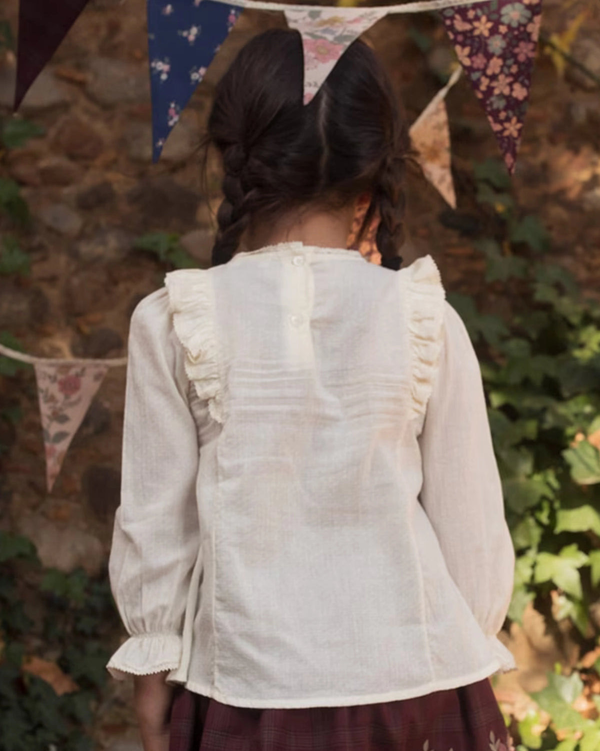 Early Sunday, Lauren Blouse in Plum, made from Printed Cotton Satin fabric, featuring layered lace-trimmed ruffles and delicate pintuck detailing on the yoke, shown in a back view of model wearing it