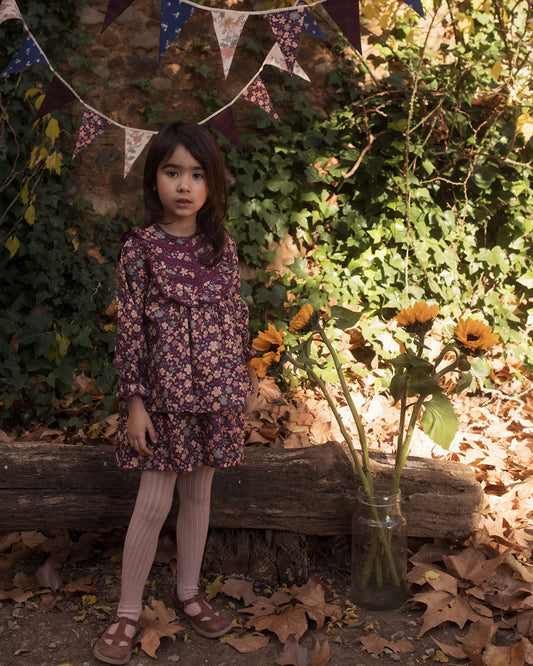 Early Sunday, Lauren Blouse in Plum, made from Printed Cotton Satin fabric, featuring layered lace-trimmed ruffles and delicate pintuck detailing on the yoke, shown in a front view of model wearing it