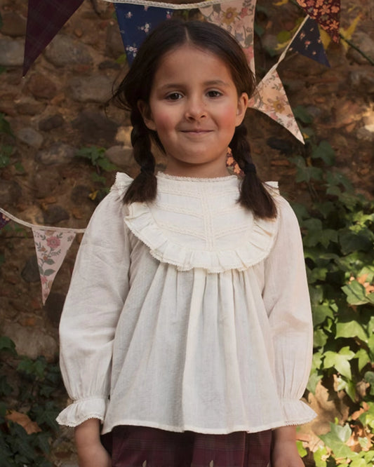Early Sunday, Lauren Blouse in Plum, made from Printed Cotton Satin fabric, featuring layered lace-trimmed ruffles and delicate pintuck detailing on the yoke, shown in a front view of model wearing it