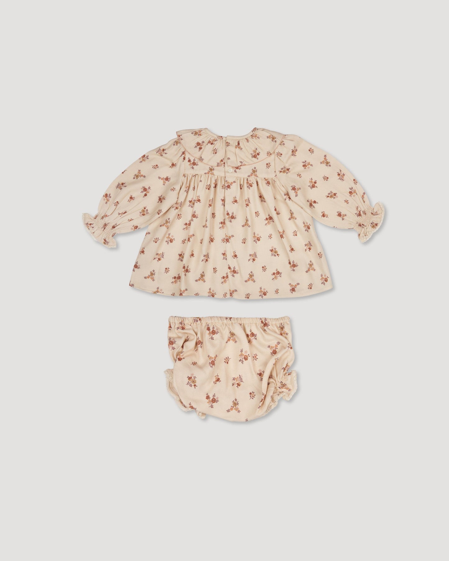 Early Sunday, Libby Baby Dress & Bloomer Set in Ditsy Bouquet Cream print color, made from Printed Viscose Rayon Twill fabric, featuring long sleeves with frilly neck & floral print, shown in a back flat-lay view