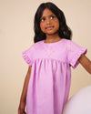 Early Sunday, Lila Dress in Lilac color, made from 70% cotton 30% linen solid fabric, featuring Scalloped neckline with contrast stitching, flutter sleeves, gentle gathers, and embroidered hem detail, shown in a front view of model wearing