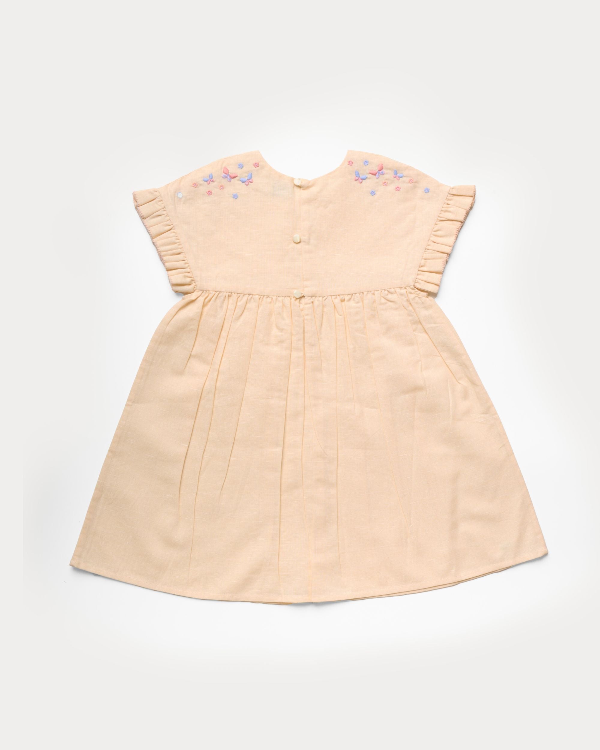 Early Sunday, Lila Dress in Sand color, made from 70% cotton 30% linen solid fabric, featuring Scalloped neckline with contrast stitching, flutter sleeves, gentle gathers, and embroidered hem detail, shown in a back flat-lay view