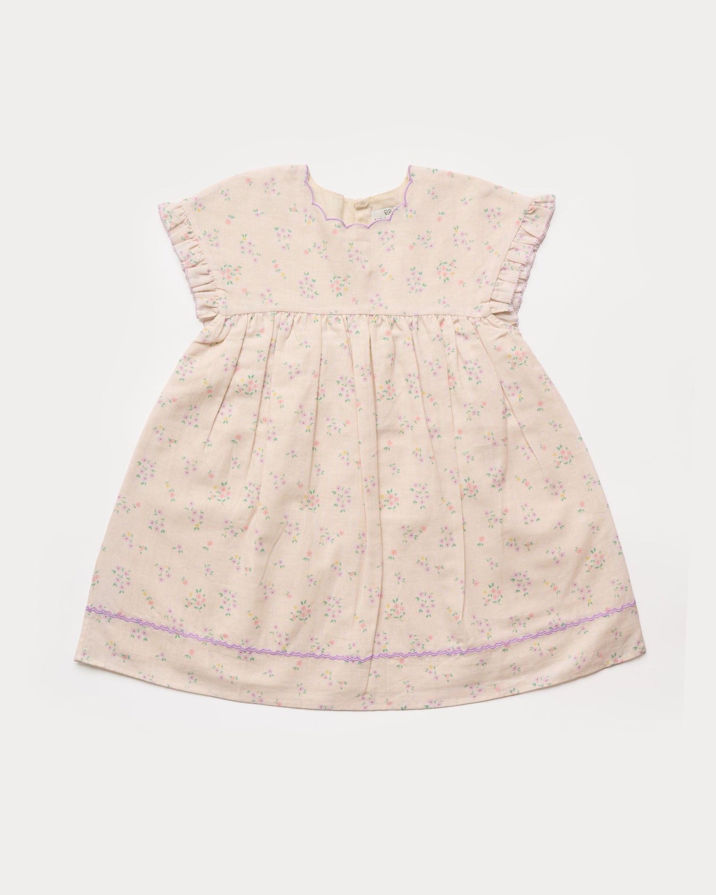 Early Sunday, Lila Dress in Painted Bouquet color, made from printed 70% cotton 30% linen fabric, featuring Scalloped neckline with contrast stitching, flutter sleeves, gentle gathers, and embroidered hem detail, shown in a front flat-lay view