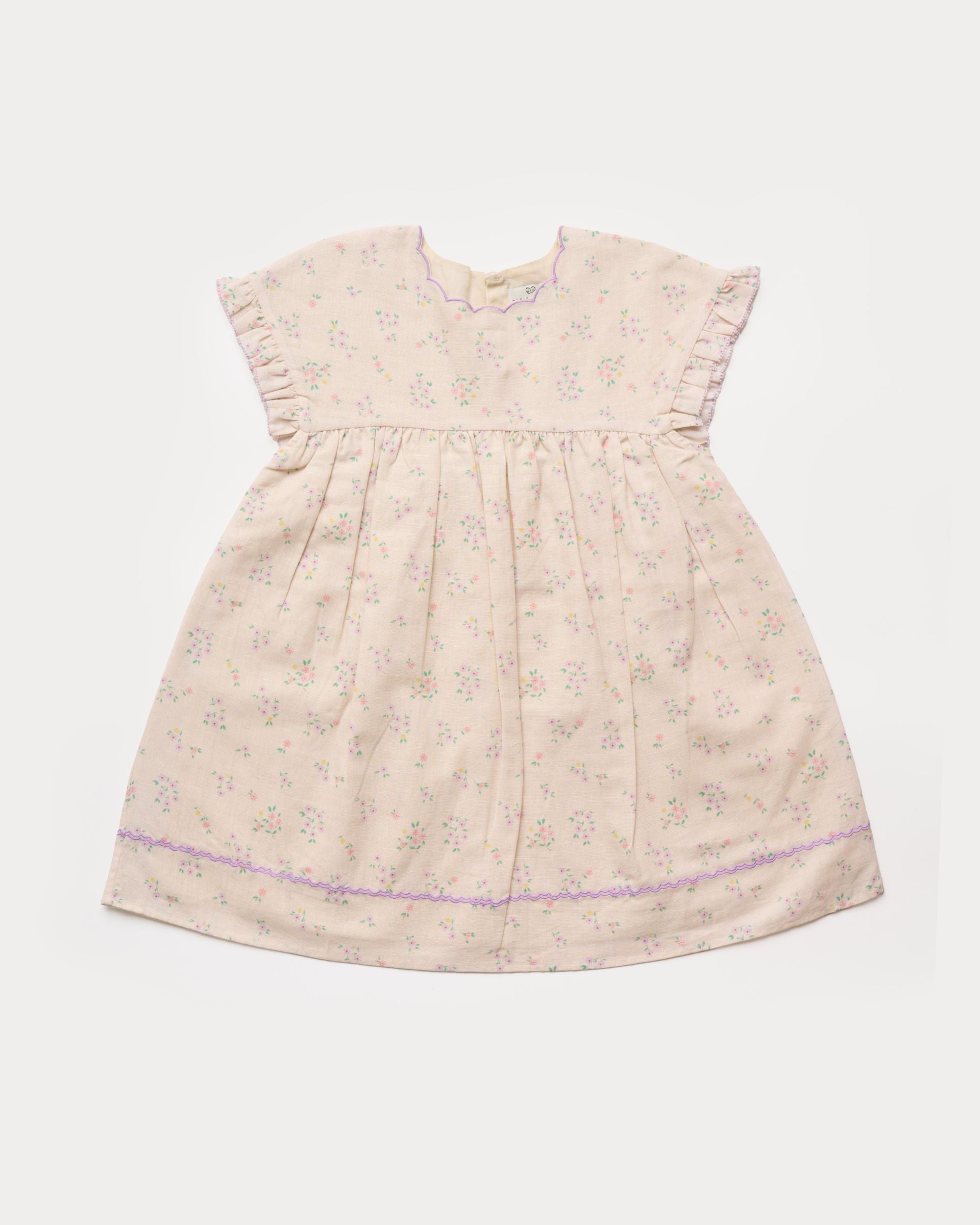 Early Sunday, Lila Dress in Painted Bouquet color, made from printed 70% cotton 30% linen fabric, featuring Scalloped neckline with contrast stitching, flutter sleeves, gentle gathers, and embroidered hem detail, shown in a front flat-lay view