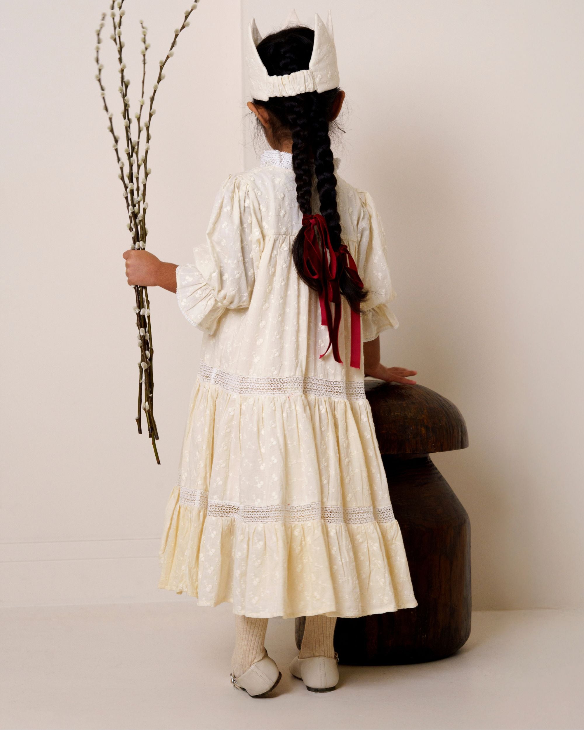 Early Sunday, Lilly Dress in Hazelnut Cream, made from All-Over Embroidered Cotton Cambric fabric, featuring Delicate floral embroidery placed softly across the dress for a timeless, heirloom-inspired finish, shown in a back view of model wearing it