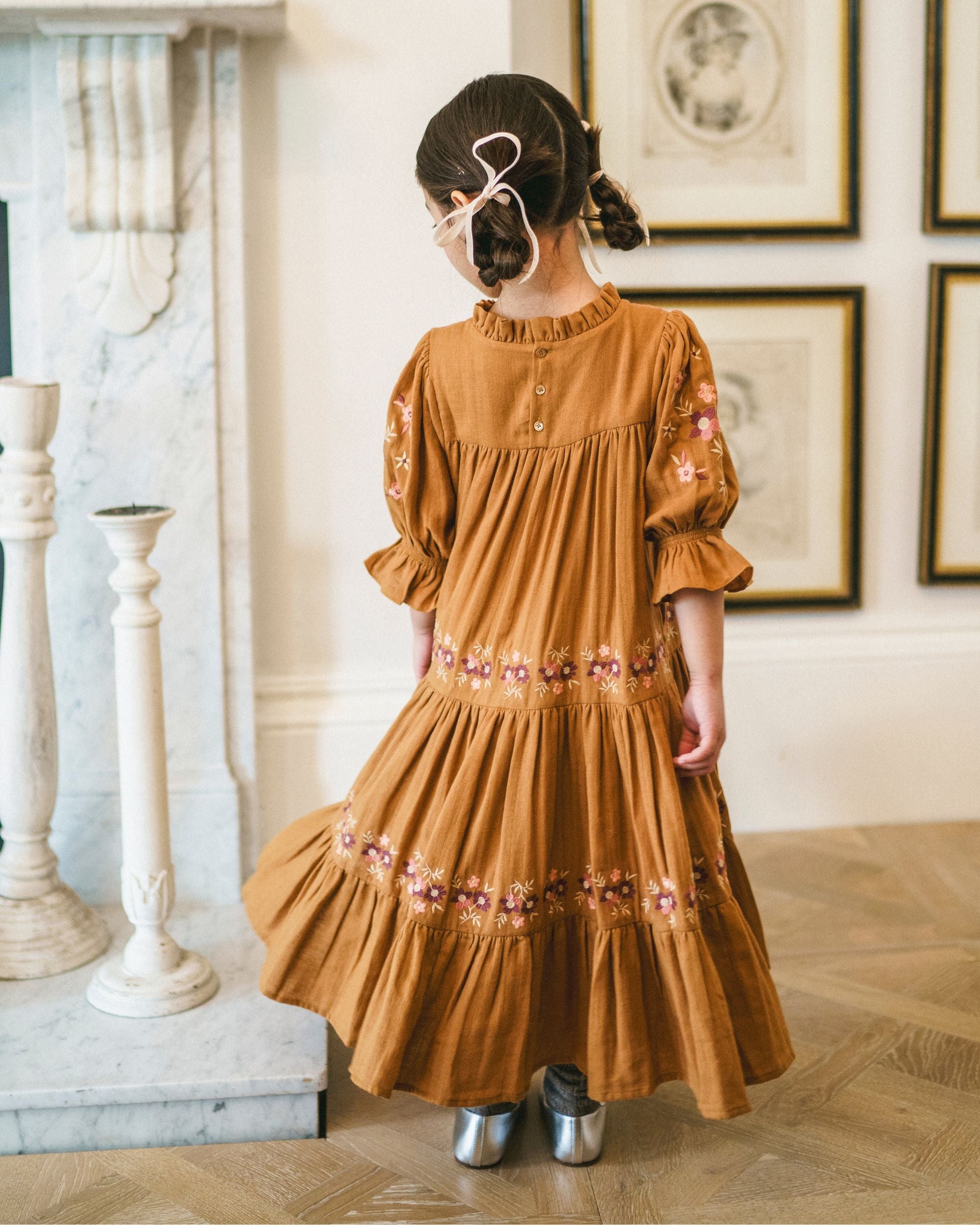 Early Sunday, Lilly Dress in Almond, made from Dyed Cotton Double Gauze fabric, featuring Delicate floral embroidery placed softly across the dress for a timeless, heirloom-inspired finish, shown in a back view of model wearing it