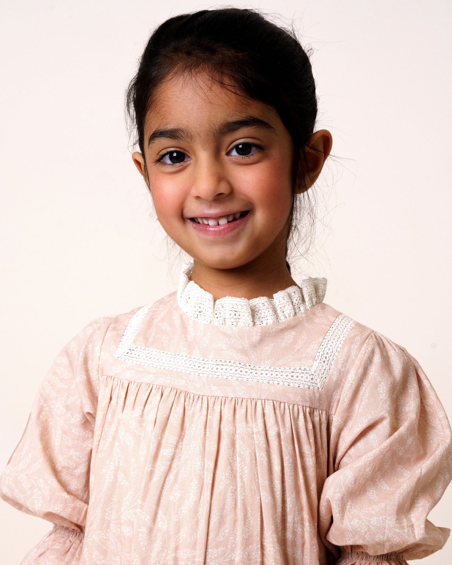 Early Sunday, Lilly Dress in Feather print, made from Printed Cotton Cambric fabric, featuring Delicate floral embroidery placed softly across the dress for a timeless, heirloom-inspired finish, shown in a front view of a model wearing it in a studio setting