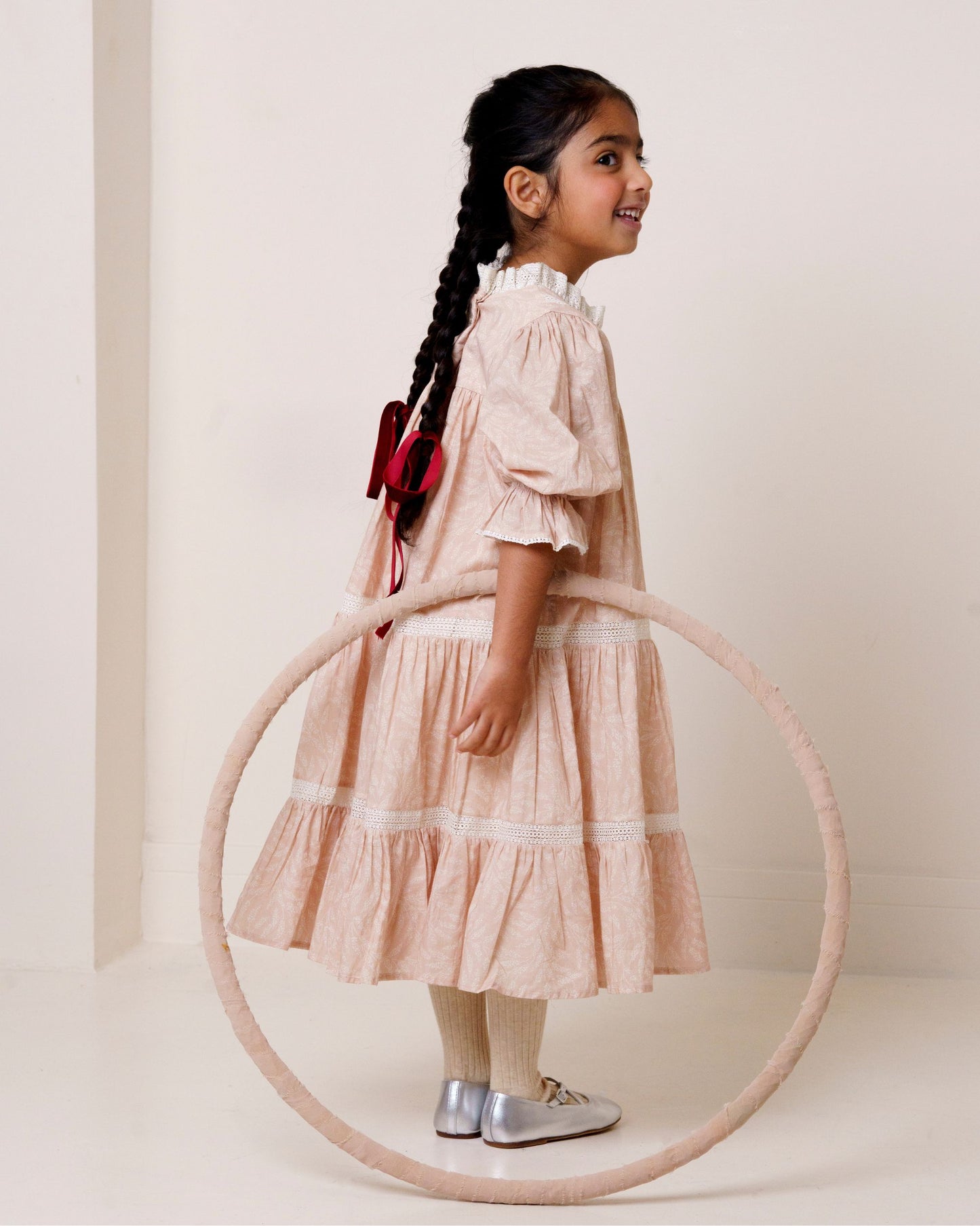 Early Sunday, Lilly Dress in Feather print, made from Printed Cotton Cambric fabric, featuring Delicate floral embroidery placed softly across the dress for a timeless, heirloom-inspired finish, shown in a side view of model wearing it