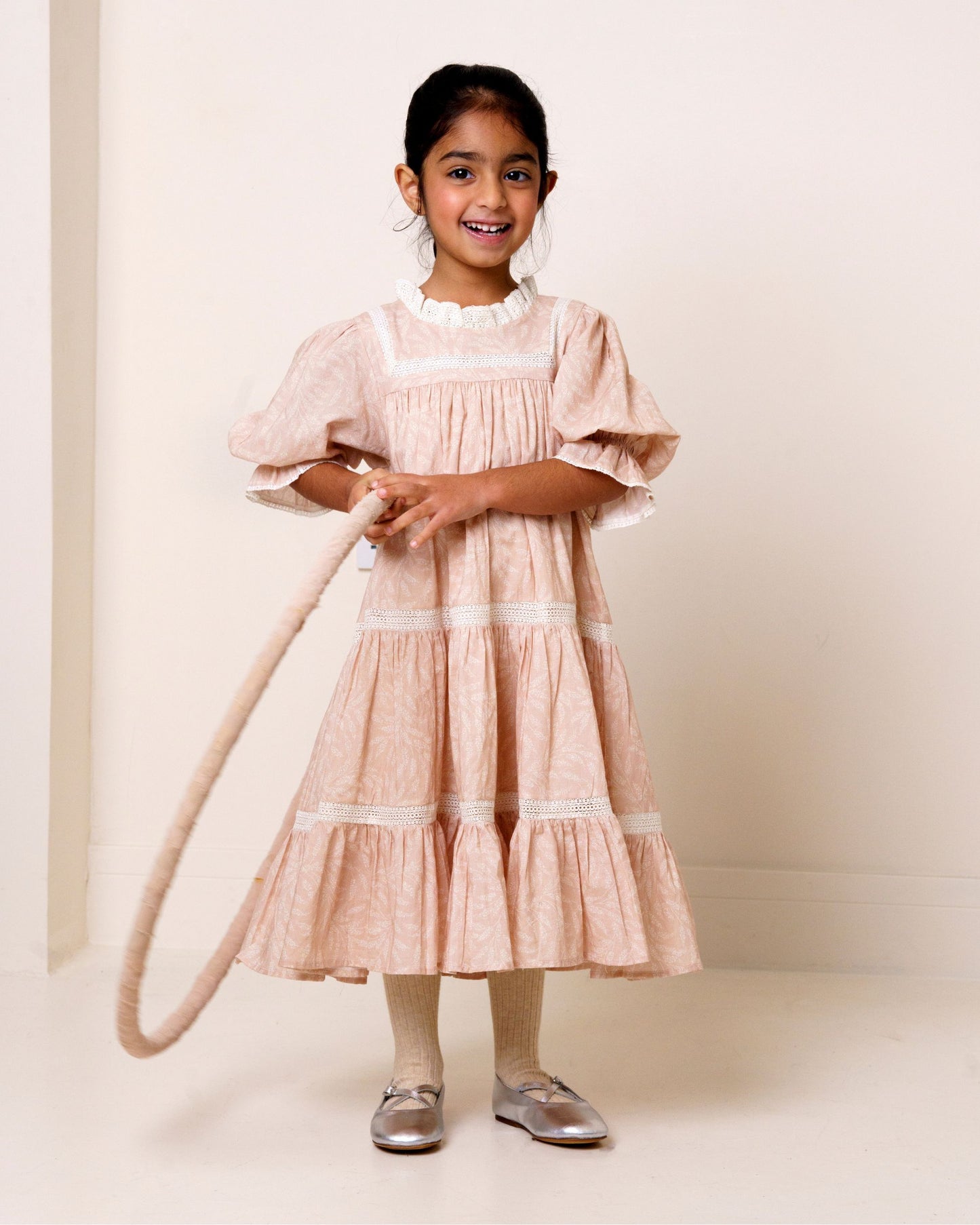 Early Sunday, Lilly Dress in Feather print, made from Printed Cotton Cambric fabric, featuring Delicate floral embroidery placed softly across the dress for a timeless, heirloom-inspired finish, shown in a front view of a model wearing it in a studio setting