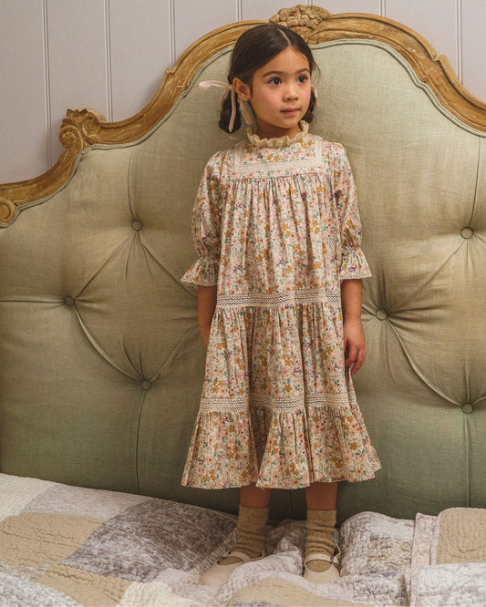 Early Sunday, Lilly Dress in Floral print, made from Printed Cotton Satin fabric, featuring Delicate floral embroidery placed softly across the dress for a timeless, heirloom-inspired finish, shown in a front view of a model wearing it in a studio setting