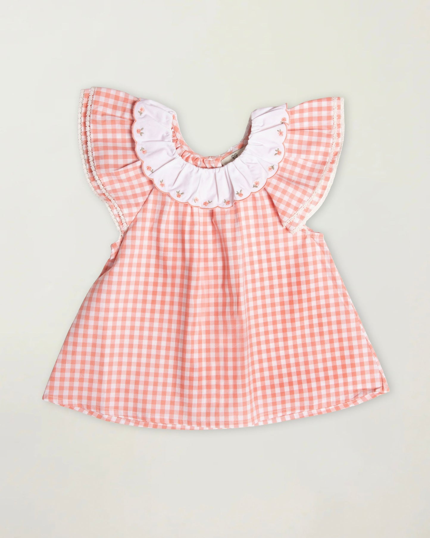 Early Sunday, Lola Blouse in Peony color, made from 100% cotton gingham checks fabric, featuring Ruffled neckline, flutter sleeves with contrast detailing, and gentle gathers for a sweet silhouette, shown in a front flat-lay view