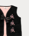 Early Sunday, Lou Vest jacket in Black, made from Cotton Velvet Velour's fabric, featuring sleeveless quilted silhouette with tie-up bow and floral embroidery, shown in a closeup flat-lay view