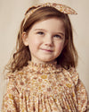 Early Sunday, Louise Dress in Garden Flowers Dusty Pink, made from Printed Cotton Satin fabric, featuring classic silhouette with a charming print, shown in a close up shot of model wearing it