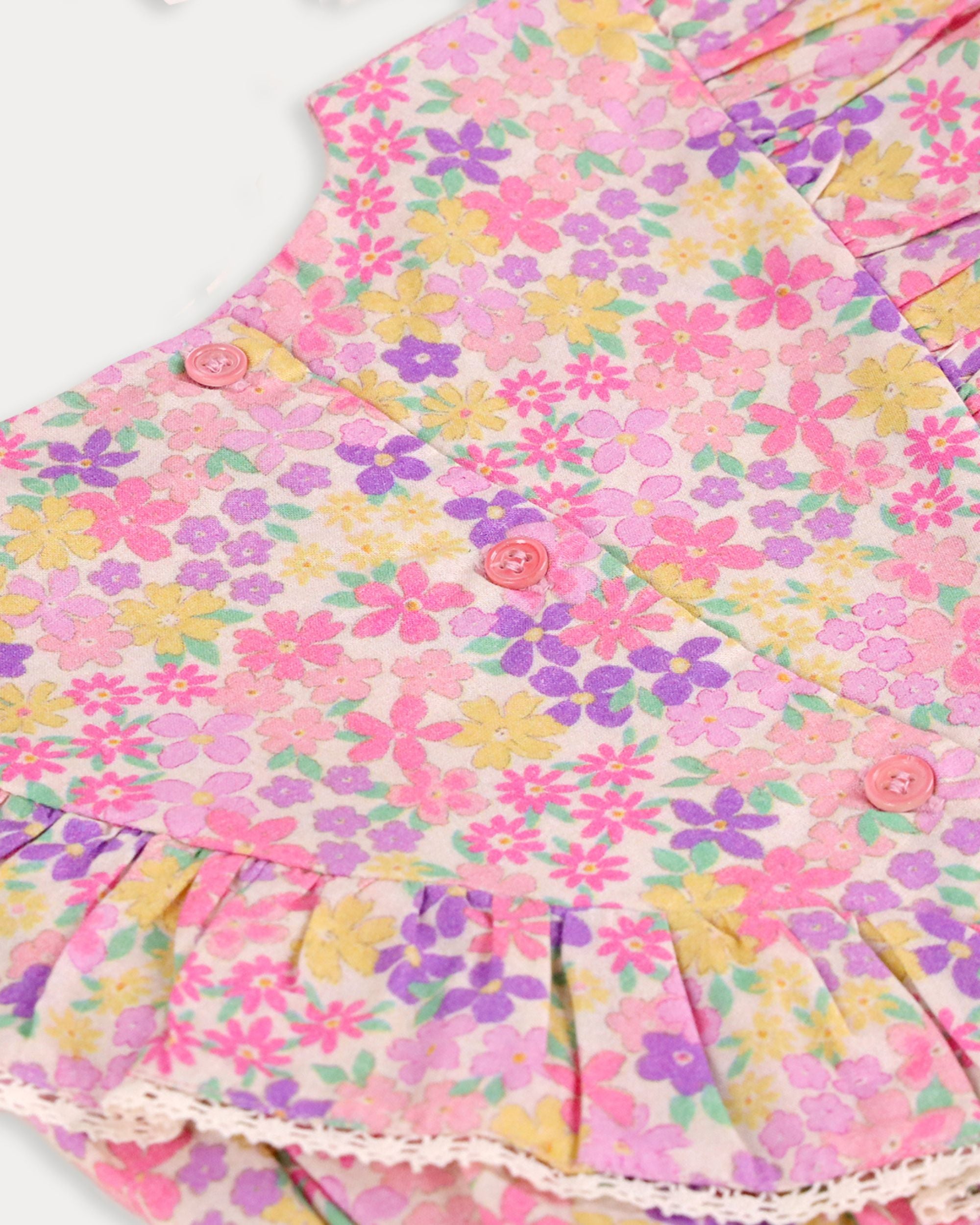Early Sunday, Lucy Baby Bubble Romper in Emma Floral Purple color, made from 100% Organic Cotton 60s Cambric fabric, featuring a floral print with lace borders, shown in a closeup flat-lay view
