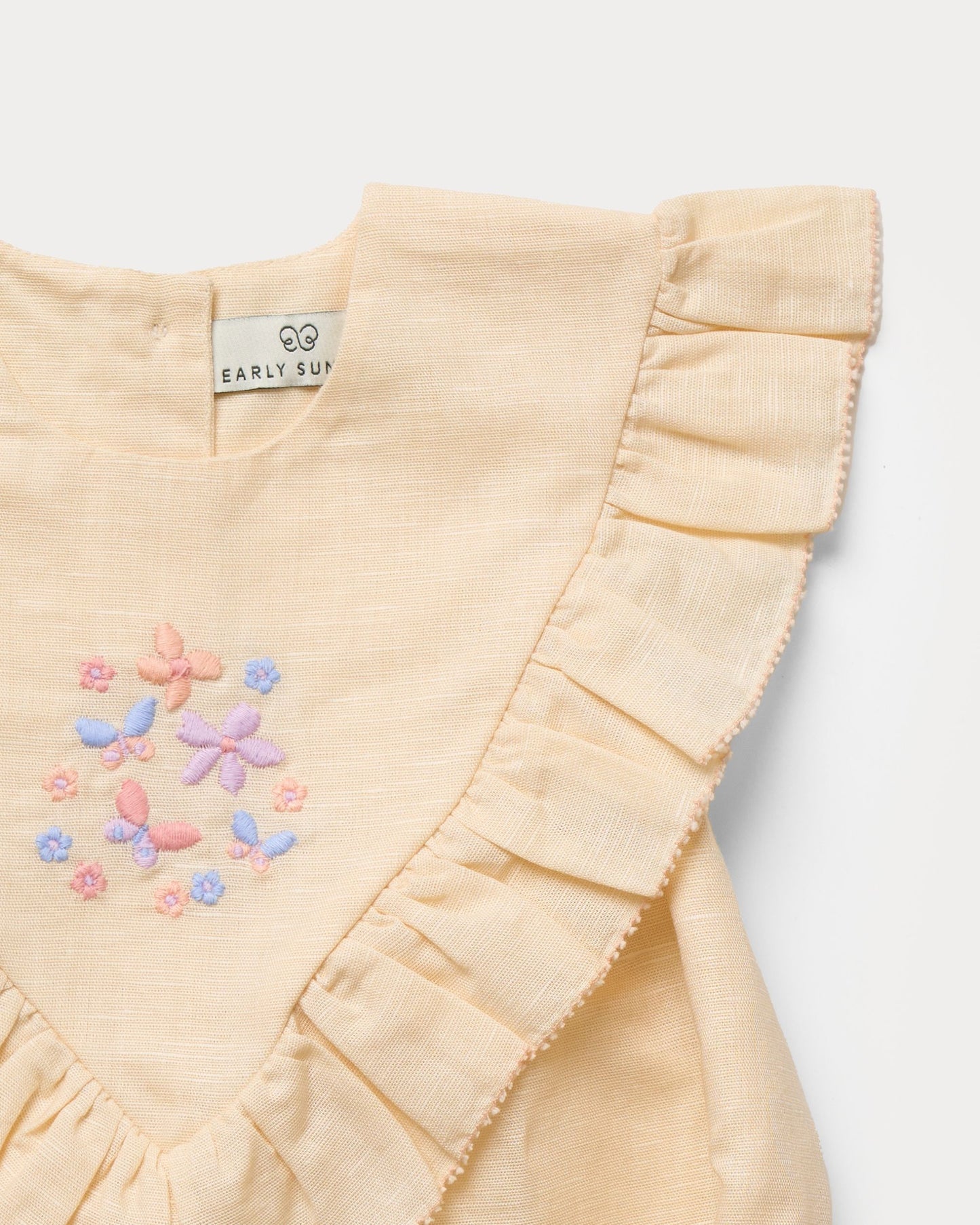 Early Sunday, Lucy Baby Bubble Romper in Sand color, made from 70% Cotton 30% Linen fabric, featuring a bubble pattern with beautiful embroidery, shown in a closeup flat-lay view