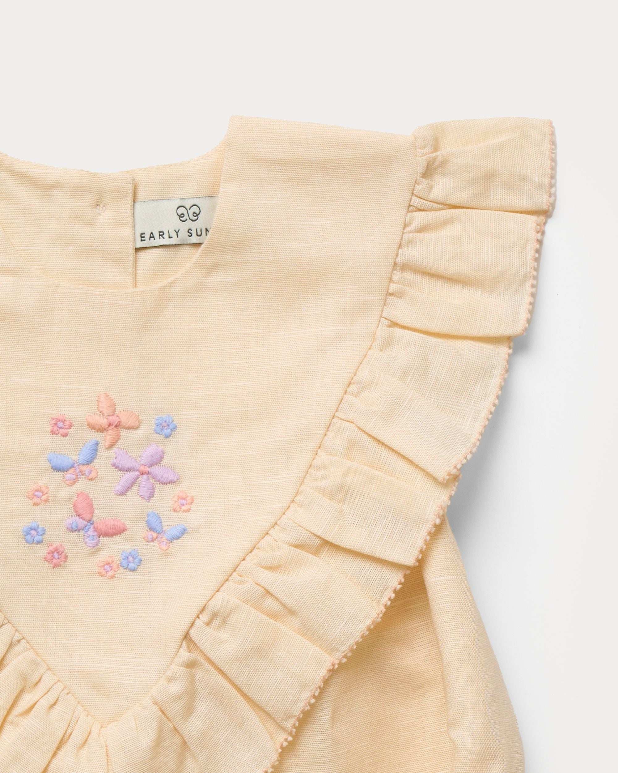 Early Sunday, Lucy Baby Bubble Romper in Sand color, made from 70% Cotton 30% Linen fabric, featuring a bubble pattern with beautiful embroidery, shown in a closeup flat-lay view