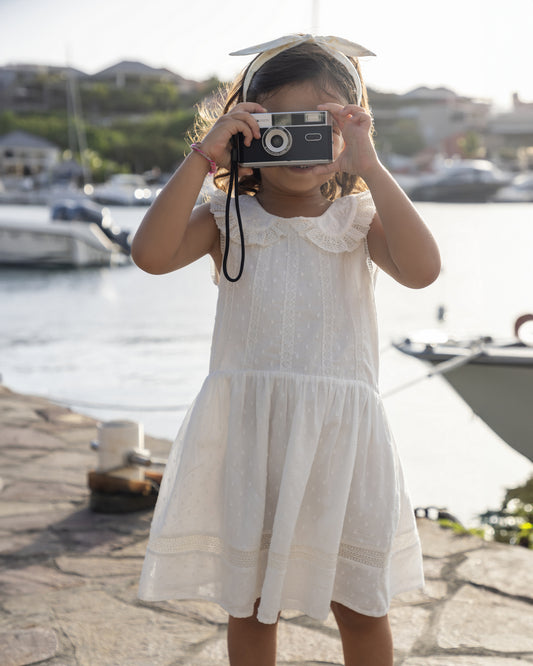 Early Sunday, LYS Dress in Ivory color, made from Cotton Dobby Swiss Dots fabric, featuring flattering fit with delicate finishes, combining style and functionality for an effortlessly elegant look, shown in a front view of model wearing it