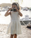 Early Sunday, LYS Dress in Ivory color, made from Cotton Dobby Swiss Dots fabric, featuring flattering fit with delicate finishes, combining style and functionality for an effortlessly elegant look, shown in a front view of model wearing outdoors