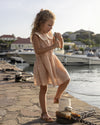 Early Sunday, LYS Dress in Garden Flowers print, made from Printed Cotton Cambric fabric, featuring flattering fit with delicate finishes, combining style and functionality for an effortlessly elegant look, shown in a outdoor shot of model wearing it