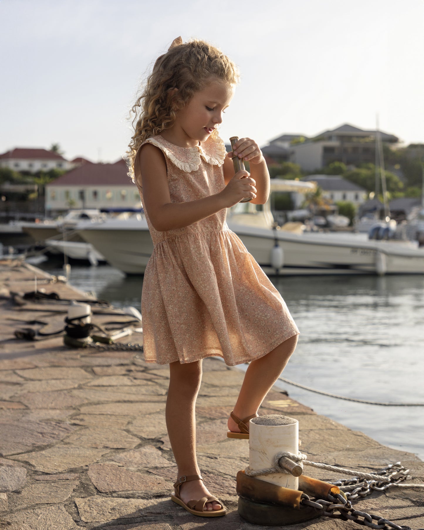 Early Sunday, LYS Dress in Garden Flowers print, made from Printed Cotton Cambric fabric, featuring flattering fit with delicate finishes, combining style and functionality for an effortlessly elegant look, shown in a outdoor shot of model wearing it