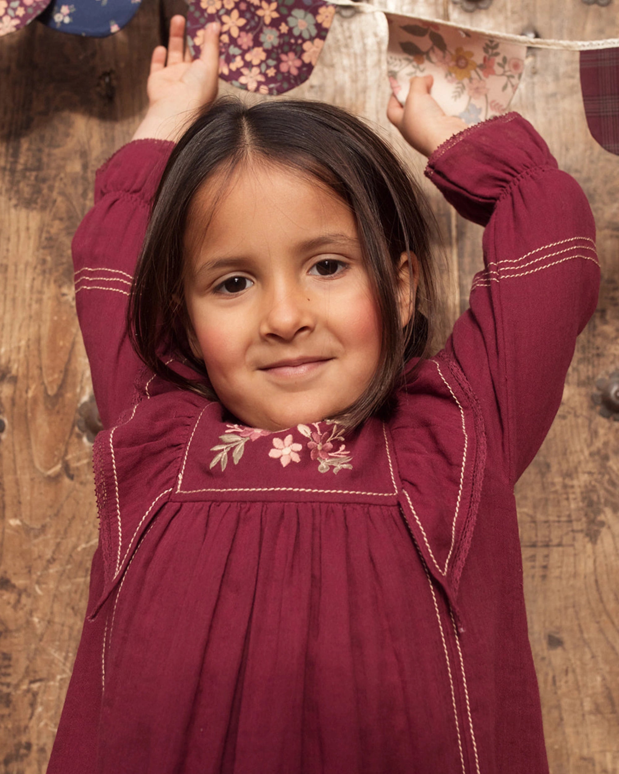 Early Sunday, Margot Dress in Plum, made from Cotton Double Gauze fabric, featuring classic silhouette with ruffle detailing around the sleeves, shown in a close up shot of model wearing it