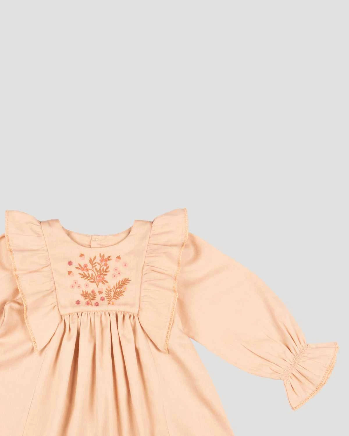 Early Sunday, Margot Dress in Beige, made from Cotton Satin fabric, featuring classic silhouette with floral embroidery around the yoke and ruffle detailing, shown in a closeup flat-lay view