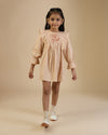 Early Sunday, Margot Dress in Beige, made from Cotton Satin fabric, featuring classic silhouette with floral embroidery around the yoke and ruffle detailing, shown in a front view of model wearing it