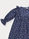 Early Sunday, Margot Dress in Ditsy Bouquet Navy, made from Printed Cotton Satin fabric, featuring classic silhouette with ruffle detailing around the sleeves, shown in a closeup flat-lay view