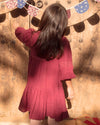 Early Sunday, Marguerite Dress in Plum, made from Cotton Double Gauze fabric, featuring floral embroidery with frilled Peter Pan collar, shown in a back view of model wearing outdoors