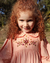 Early Sunday, Marguerite Dress in Blush Pink, made from Cotton Satin fabric, featuring floral embroidery with frilled Peter Pan collar, shown in a close up shot of model wearing it