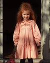 Early Sunday, Marguerite Dress in Blush Pink, made from Cotton Satin fabric, featuring floral embroidery with frilled Peter Pan collar, shown in a front view of model wearing outdoors