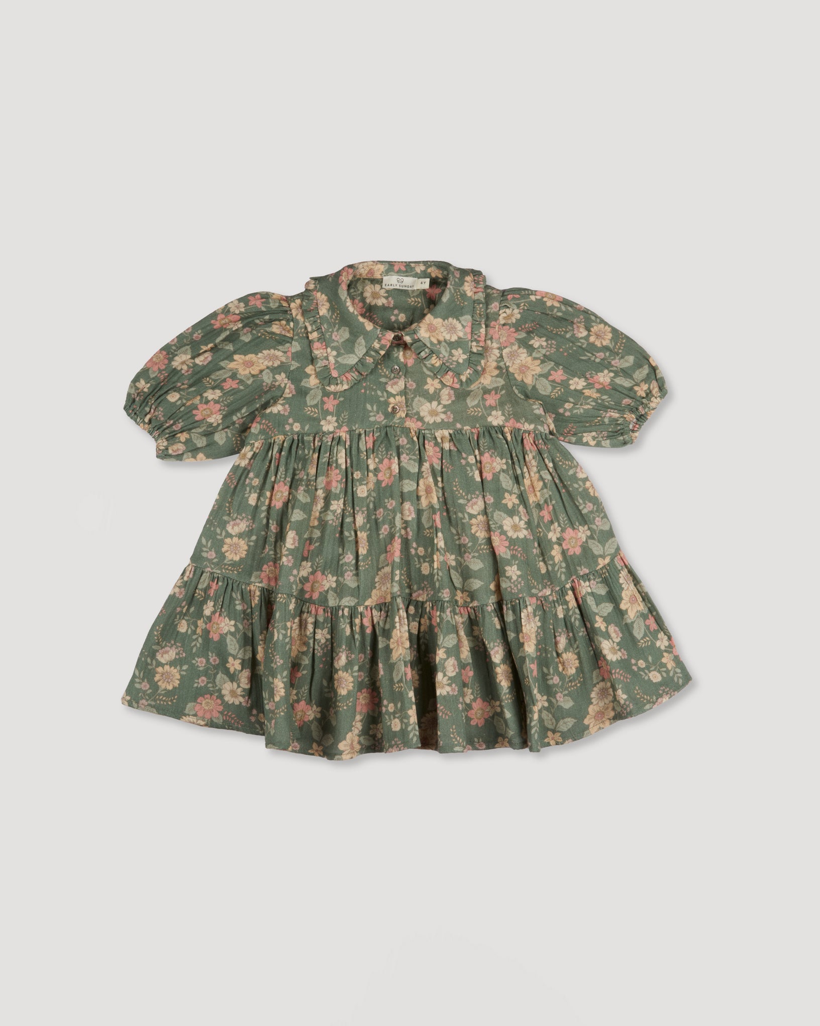Early Sunday, Marguerite Dress in Autumn Bloom Soft Green, made from Printed Cotton Double Gauze fabric, featuring classic silhouette with a collar and ruffle detailing, shown in a back flat-lay view
