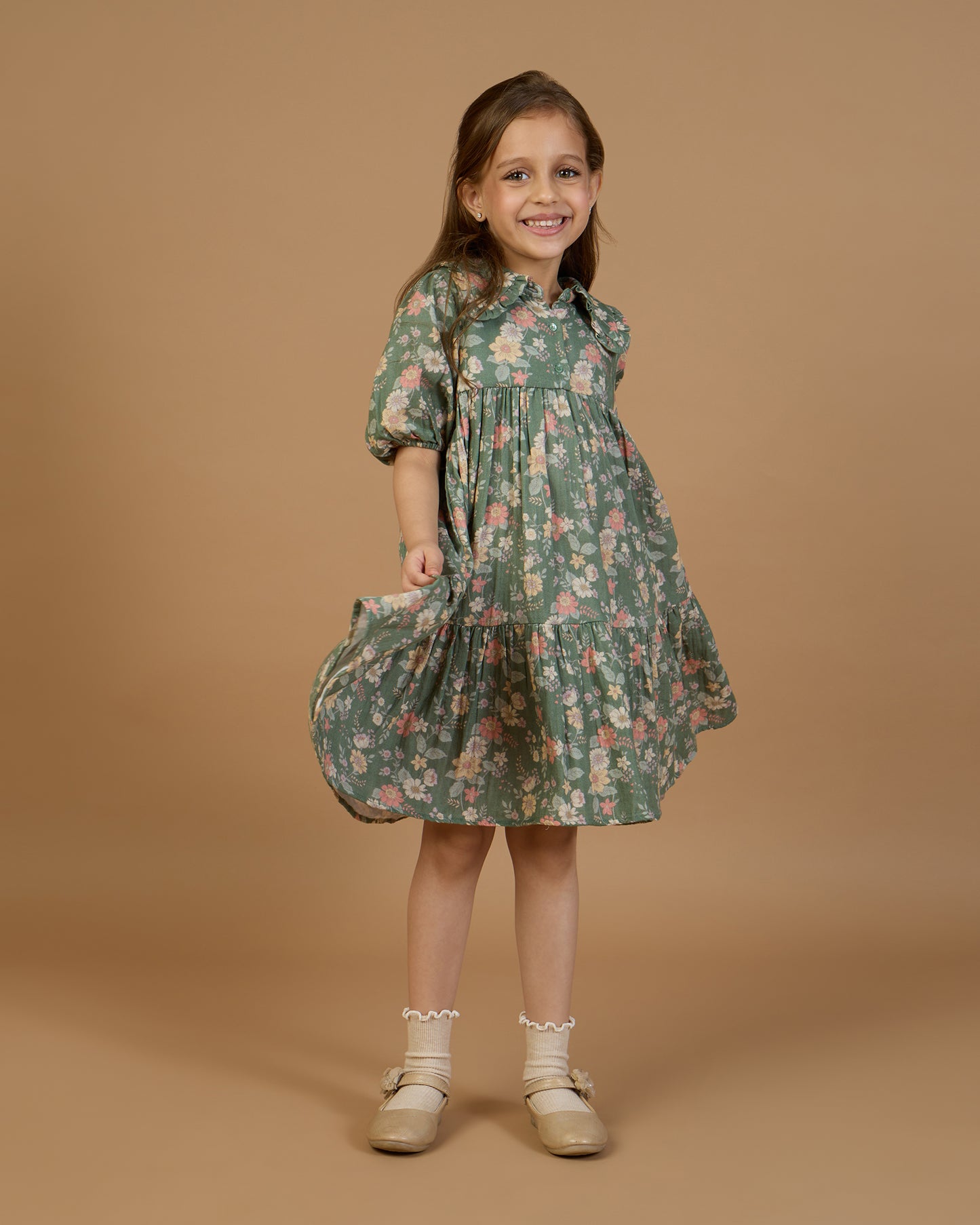 Early Sunday, Marguerite Dress in Autumn Bloom Soft Green, made from Printed Cotton Double Gauze fabric, featuring classic silhouette with a collar and ruffle detailing, shown in a front view of model wearing it