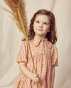 Early Sunday, Marguerite Dress in Acorn Dusty Pink, made from Printed Cotton Double Gauze fabric, featuring classic silhouette with a collar and ruffle detailing, shown in a front view of a model wearing it in a studio setting