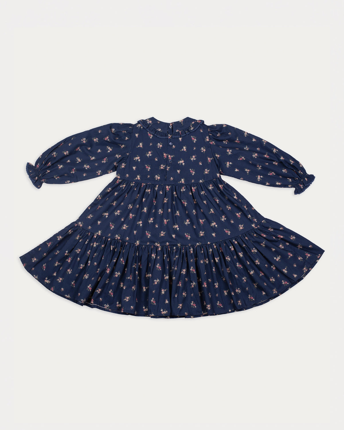 Early Sunday, Marguerite Dress in Ditsy Bouquet Navy, made from Printed Cotton Satin fabric, featuring gathered sleeves with frilled Peter Pan collar, shown in a back flat-lay view