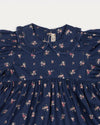 Early Sunday, Marguerite Dress in Ditsy Bouquet Navy, made from Printed Cotton Satin fabric, featuring gathered sleeves with frilled Peter Pan collar, shown in a closeup flat-lay view