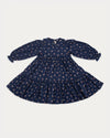 Early Sunday, Marguerite Dress in Ditsy Bouquet Navy, made from Printed Cotton Satin fabric, featuring gathered sleeves with frilled Peter Pan collar, shown in a front flat-lay view