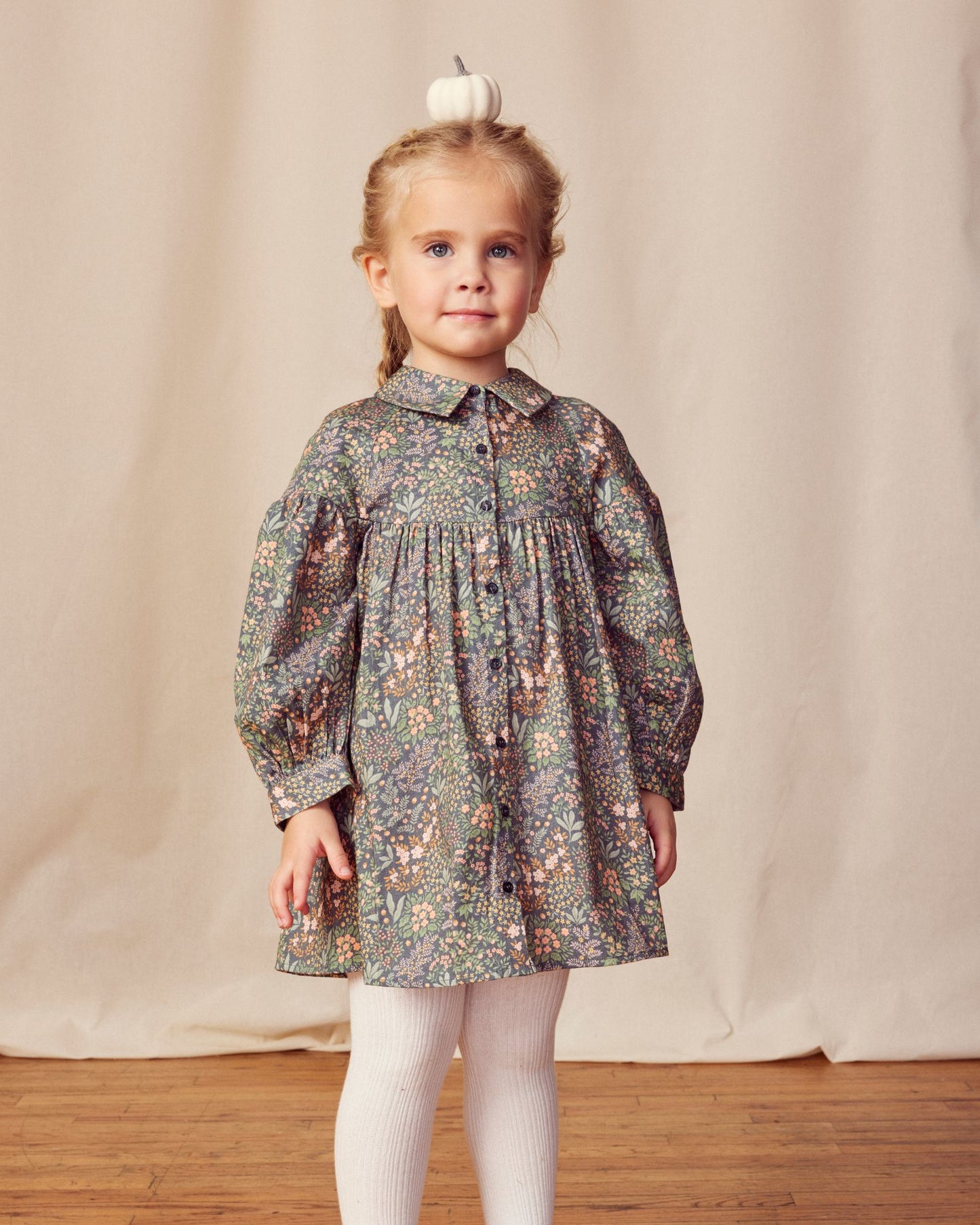 Early Sunday, Melanie Dress in Autumn Garden Greyish Blue, made from Printed Cotton Satin fabric, featuring classic silhouette with a collar, shown in a front view of a model wearing it in a studio setting