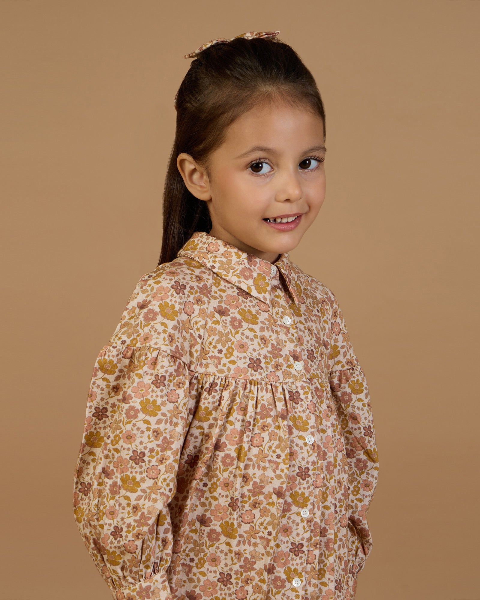 Early Sunday, Melanie Dress in Garden Flowers Dusty Pink, made from Printed Cotton Satin fabric, featuring classic silhouette with a collar, shown in a front view of a model wearing it in a studio setting