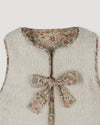 Early Sunday, Milly Baby Quilted Gilet (Reversible) in Garden Flowers print, made from Printed Cotton Cambric fabric, featuring reversible design for versatile styling, shown in a closeup flat-lay view