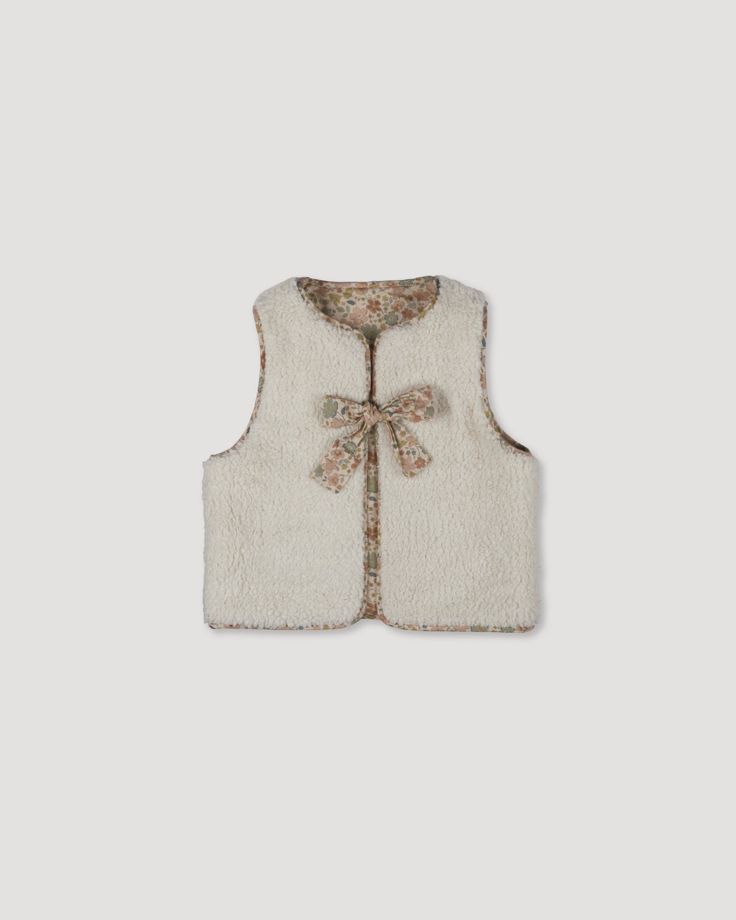Early Sunday, Milly Baby Quilted Gilet (Reversible) in Garden Flowers print, made from Printed Cotton Cambric fabric, featuring reversible design for versatile styling, shown in a front flat-lay view
