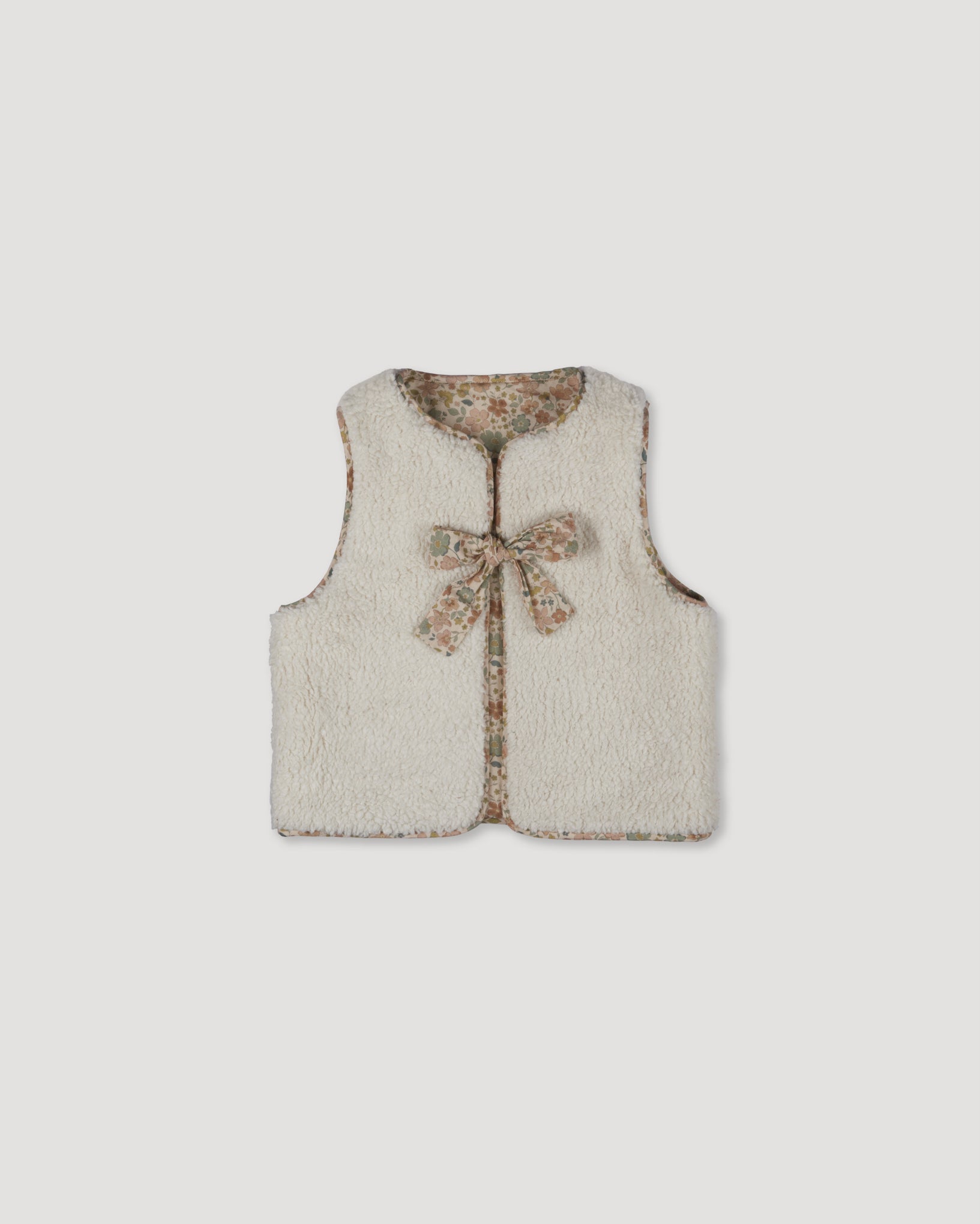Early Sunday, Milly Baby Quilted Gilet (Reversible) in Garden Flowers print, made from Printed Cotton Cambric fabric, featuring reversible design for versatile styling, shown in a front flat-lay view