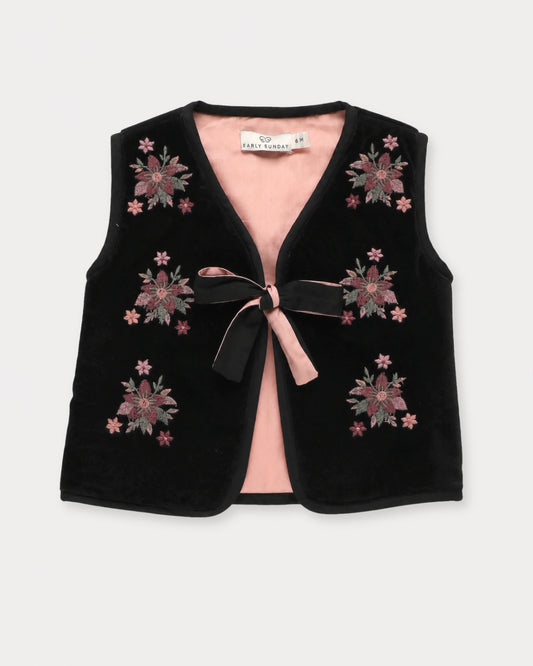 Early Sunday, Milly Baby Quilted Gilet in Black, made from Cotton Velvet Velour's fabric, featuring a floral embroidery with a bow tie, shown in a front flat-lay view