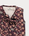 Early Sunday, Milly Baby Quilted Gilet in Garden Flowers Plum, made from Printed Cotton Satin fabric, featuring a sleeveless jacket with a bow tie, shown in a closeup flat-lay view