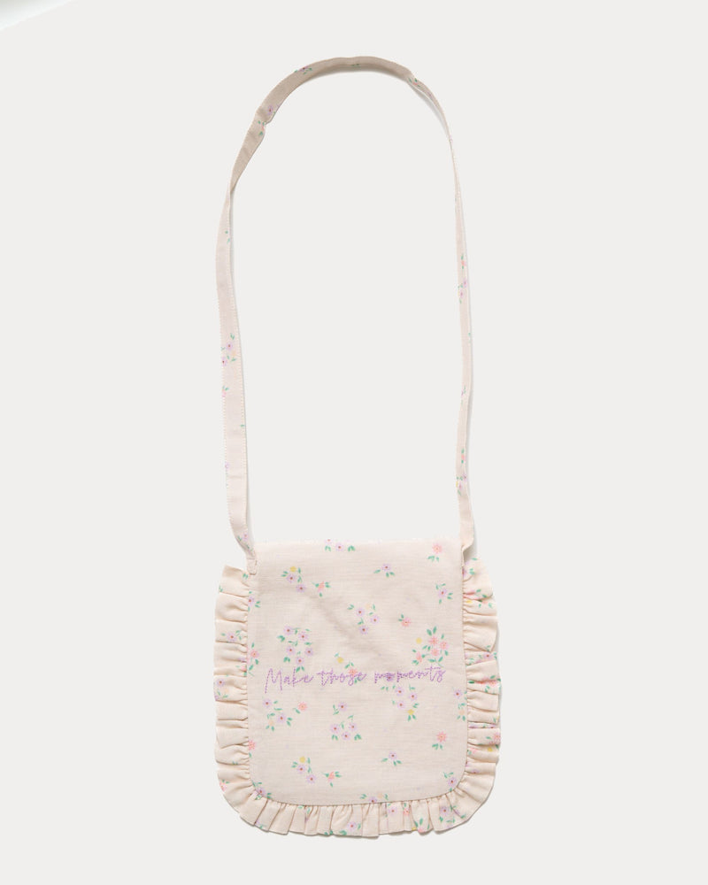 Early Sunday, Miss Sunday Sling in Painted Bouquet print, made from 70% Cotton, 30% Linen fabric, featuring a frill detailed sling purse with flap closure, shown in a back flat-lay view