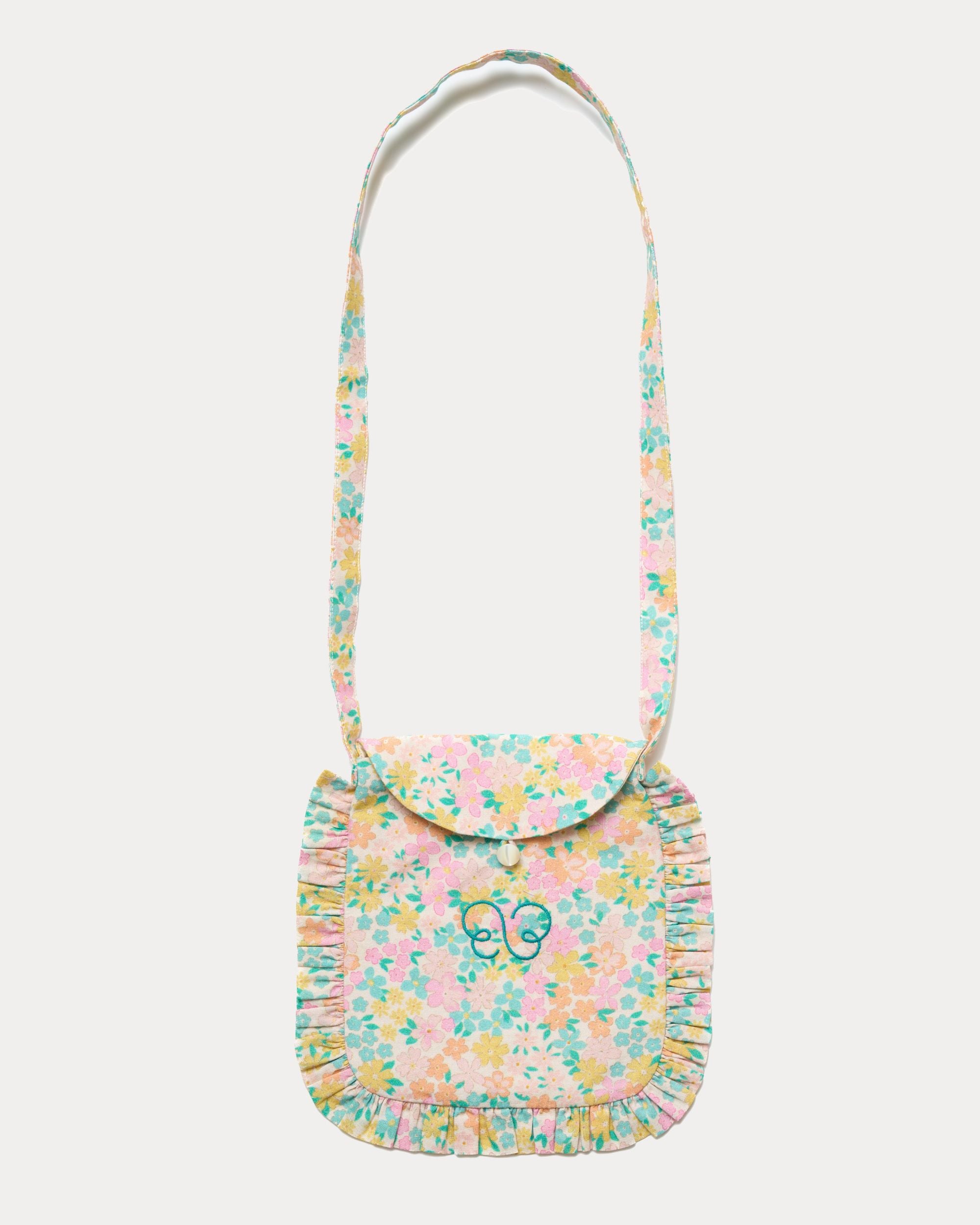 Early Sunday, Miss Sunday Sling in Emma Floral Mint color, made from Organic Printed Cotton Cambric fabric, featuring a frill detailed sling purse with flap closure, shown in front flat-lay view